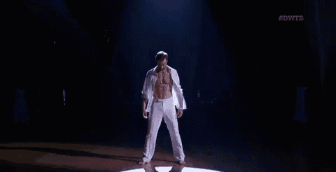 a shirtless man is dancing on a stage without a shirt on .