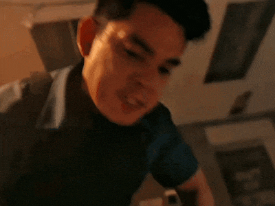 a man with a backpack on his back looks down at something