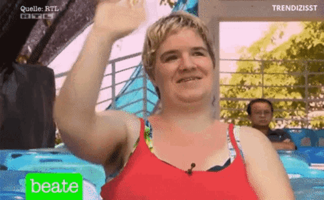 a woman in a red tank top with the word beate on the bottom right