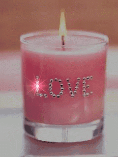 a pink candle has the word love written on it