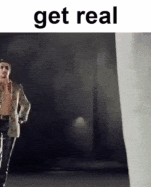 a man without a shirt is standing in front of a white curtain with the words get real on the bottom .