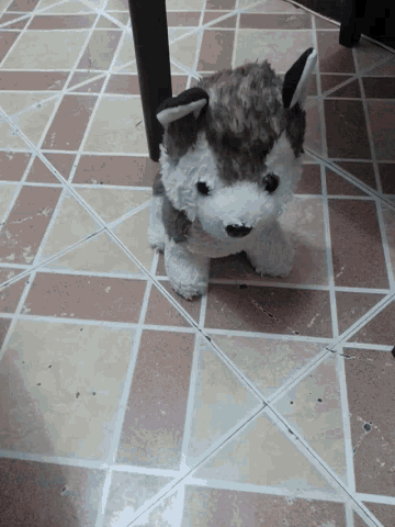 a stuffed dog laying on a tile floor