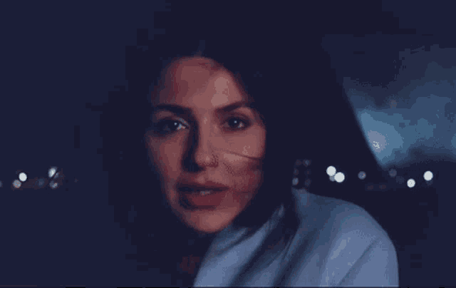 a woman in a blue coat is smiling and looking at the camera