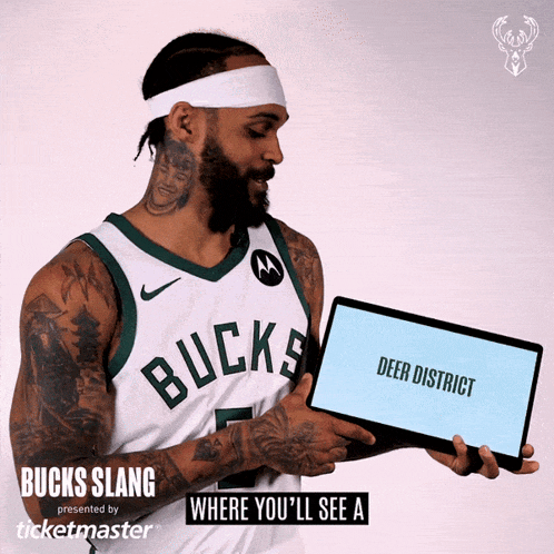 a man in a bucks jersey holding a tablet