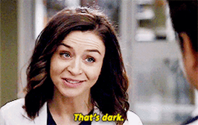 a woman is smiling and talking to a man and says `` that 's dark '' .