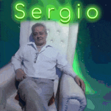 a man in a white shirt is sitting in a chair with the name sergio written in neon