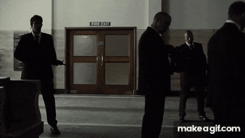 a group of men standing in front of a fire exit door