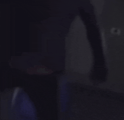 a blurry picture of two people standing next to each other in the dark .