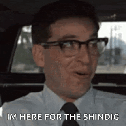 a man wearing glasses and a tie is sitting in a car and says `` im here for the shingig '' .