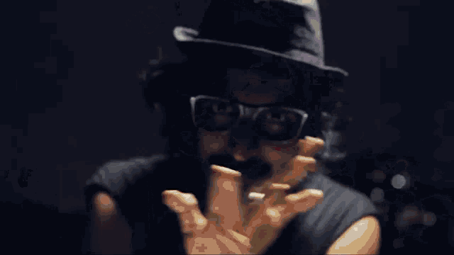 a man with a beard wearing a black hat and glasses