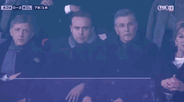 a group of people watching a soccer game on fox 2
