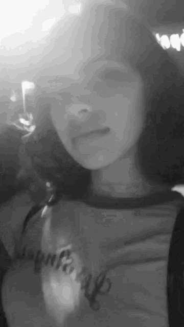 a black and white photo of a girl wearing a t-shirt that says ' i am a girl ' on it