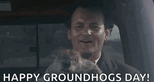 a man is sitting in a car with a groundhog in his lap .