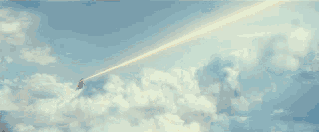 a jet is flying through a cloudy sky with a rope attached to it