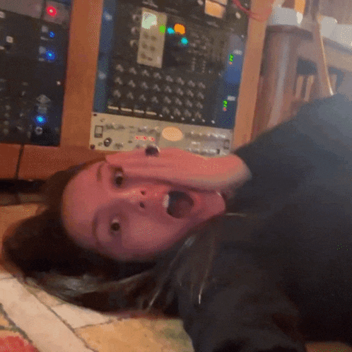 a woman is laying on her back with her mouth open