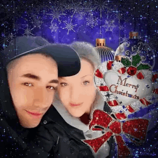 a man and a woman are posing for a picture with a merry christmas decoration in the background