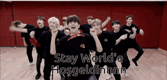 a group of young men are dancing in a room with the words stay world 'e hogeldinnn written on the bottom