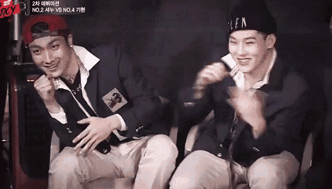 two men are sitting next to each other and one of them is wearing a hat that says len .