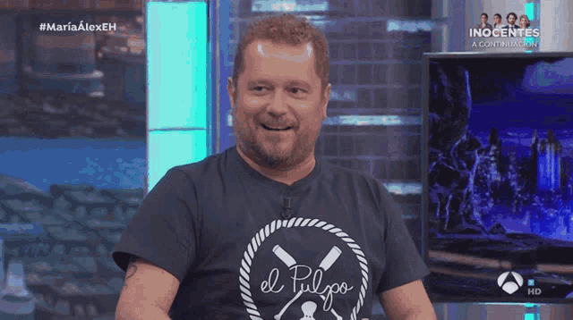 a man is laughing while wearing a shirt that says el polo