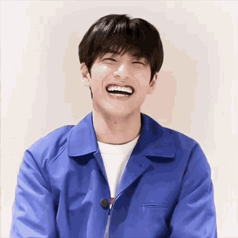 a young man wearing a blue jacket is laughing