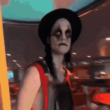 a woman dressed as a clown is standing in a restaurant