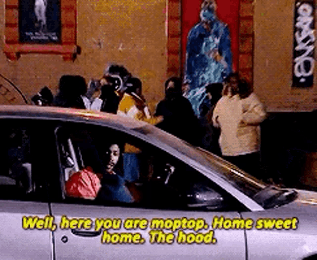 a group of people are standing around a car that says well here you are moptop home sweet home . the hood .