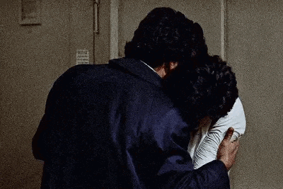 a man and a woman are hugging each other in front of a door .