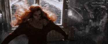 a woman with red hair is standing in front of a window with a sign that says all powers