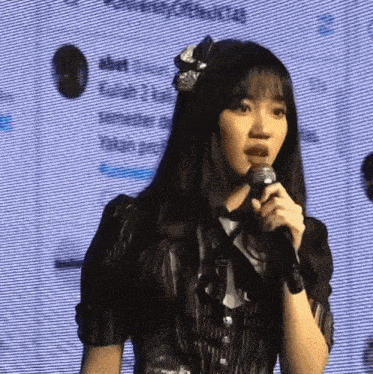 a girl with long hair is holding a microphone