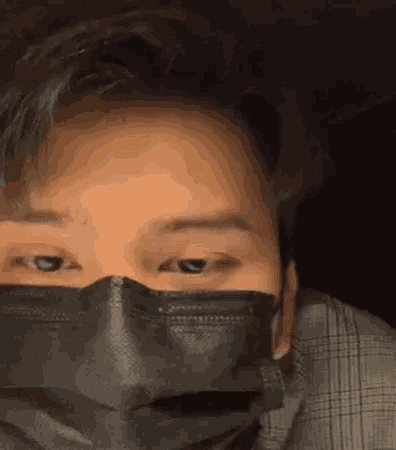 a close up of a man wearing a black mask on his face .