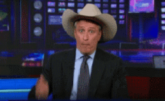 a man in a suit and tie wearing a cowboy hat and tie