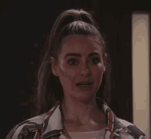 a woman with her hair in a ponytail is making a face