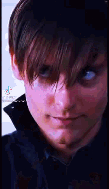 a close up of a man 's face with blue eyes and a black shirt on .