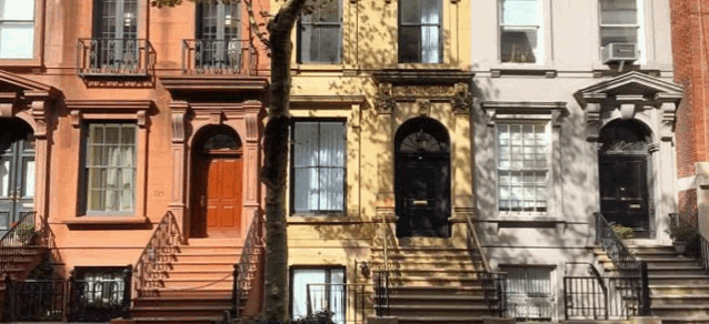 a row of buildings with stairs and balconies on a city street