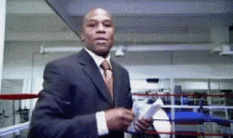 a man in a suit and tie is standing in a gym