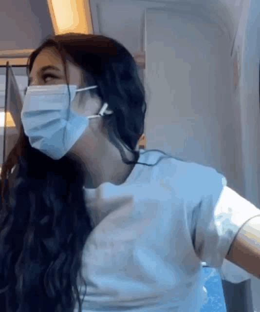 a woman wearing a face mask and headphones on a train