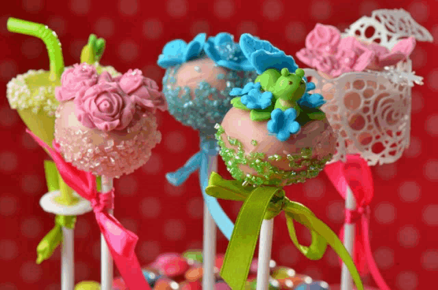 colorful cake pops with frogs and flowers on them