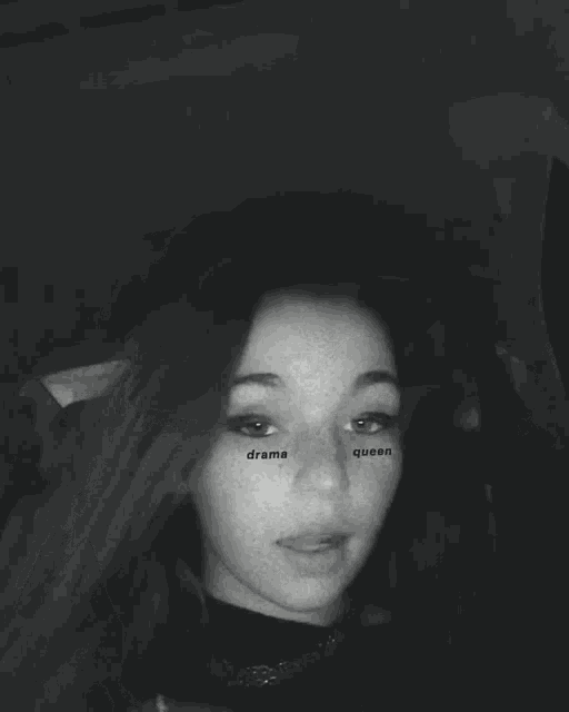 a black and white photo of a girl with drama queen written on her eyes .