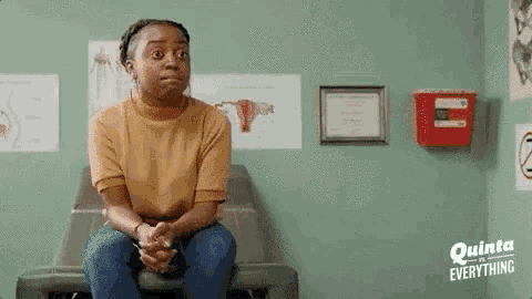 a woman is sitting on a table in a doctor 's office with a shocked look on her face .