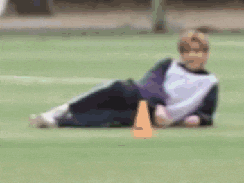 a kitten is laying on its back on a white blanket