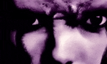 it is a close up of a person 's face with purple eyes .