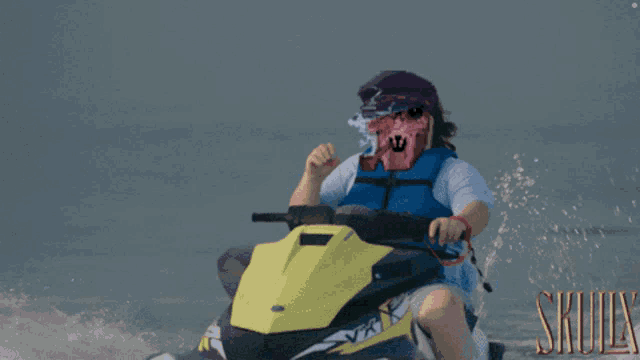 a man wearing a life vest is riding a scooter with skulls written in gold on the bottom