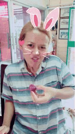 a woman with bunny ears on her head holds a purple object