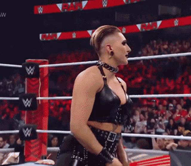a woman is standing in a wrestling ring wearing a choker and a black top