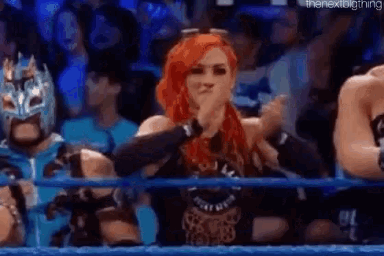a woman with red hair is sitting in the stands of a wrestling match .