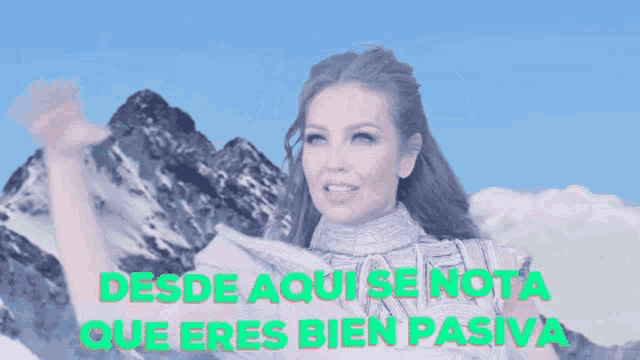 a woman waving in front of a snowy mountain with the words desde aqui se nota que eres bien pasiva