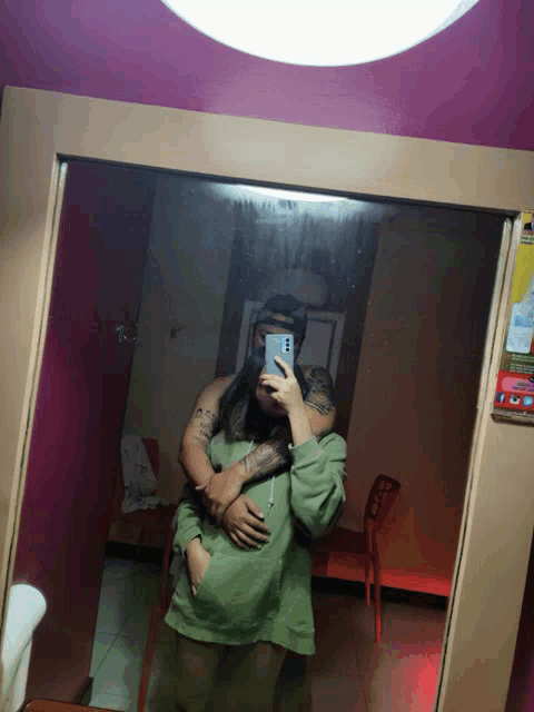 a man and a woman are taking a picture in a mirror