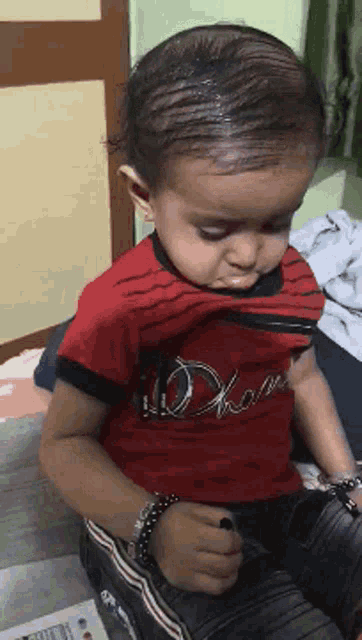 a little boy wearing a red shirt that says ' i love ' on it