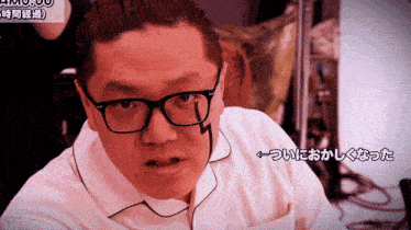 a man wearing glasses and a white shirt has chinese writing on his chest