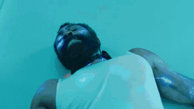 a man with a beard has blue paint on his face and body